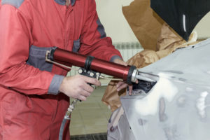 Man repairing dents with professional tool